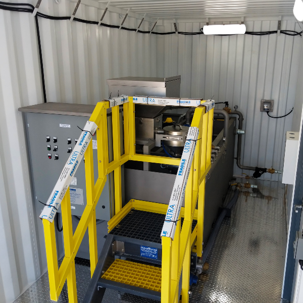 A dry polymer system with yellow handrail stairs in a container.