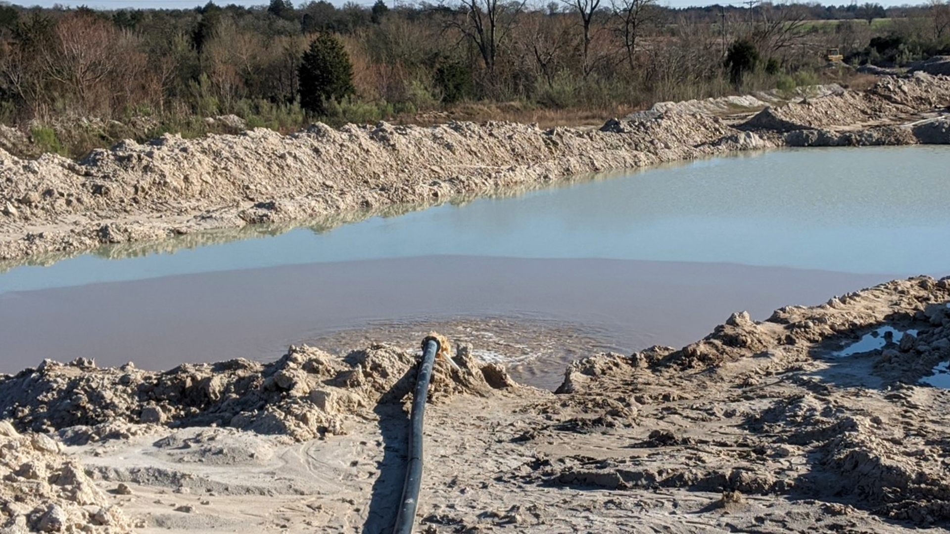 A pond with a clear line where the dirty water stops and clean water begins due to particles falling out of liquid suspension.