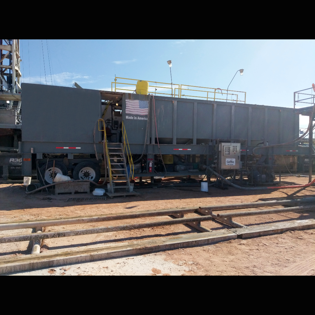 A rectangular portable water clarifier setup at a job site with the door to the control room open.
