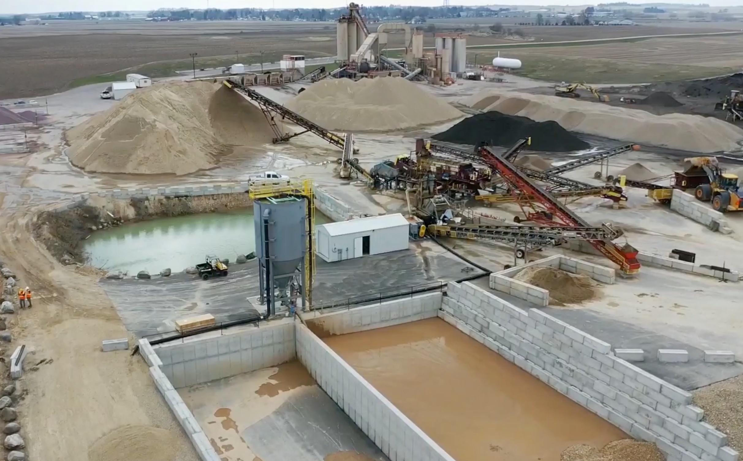 Tri-County site photo An arial photo of an aggregate production site with mud cells and clarifier in the foreground and aggregate piles and equipment in the background.