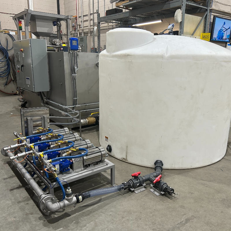 A 1000-gallon white plastic tank, 4 motor driven pumps on a skid, and PLC controlled 304SS dry polymer make-down system.