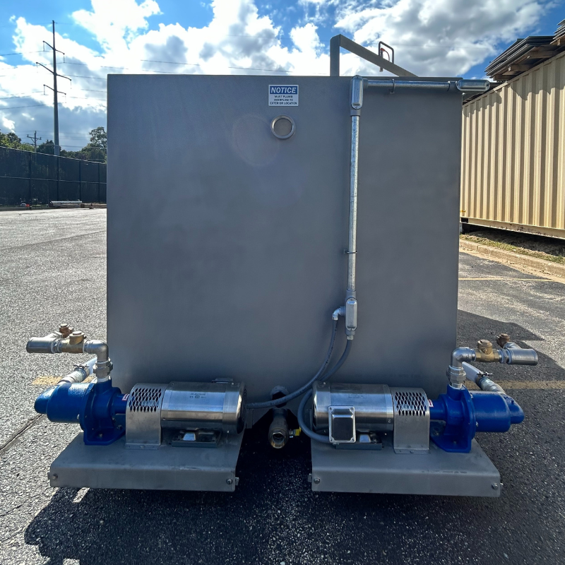 The back of Clearwater Industries standard M-Series dry polymer make-down system tank with two motor driven metering pumps and electrical conduit.